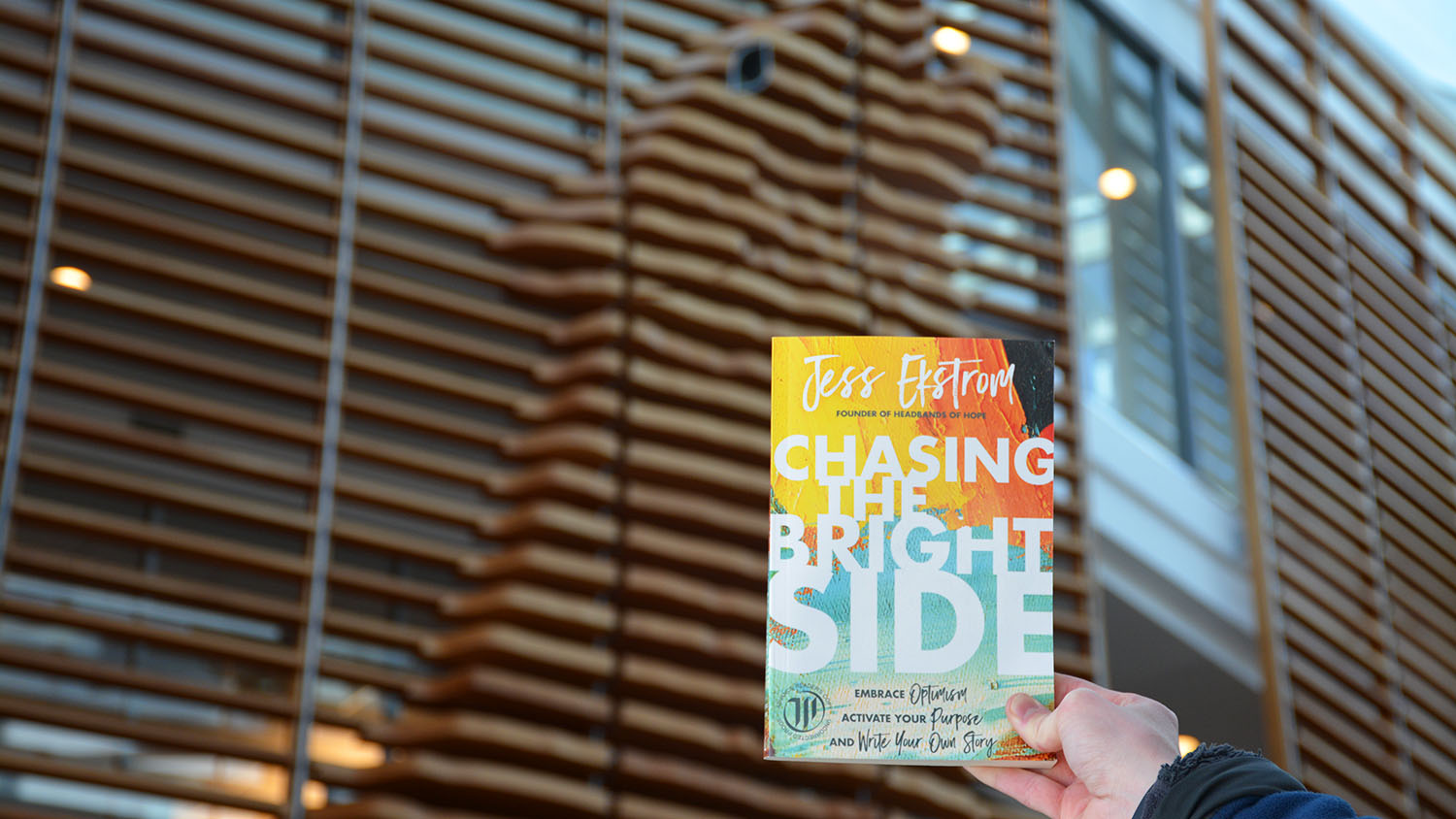 "Chasing The Bright Side" book held in air in Talley Student Union