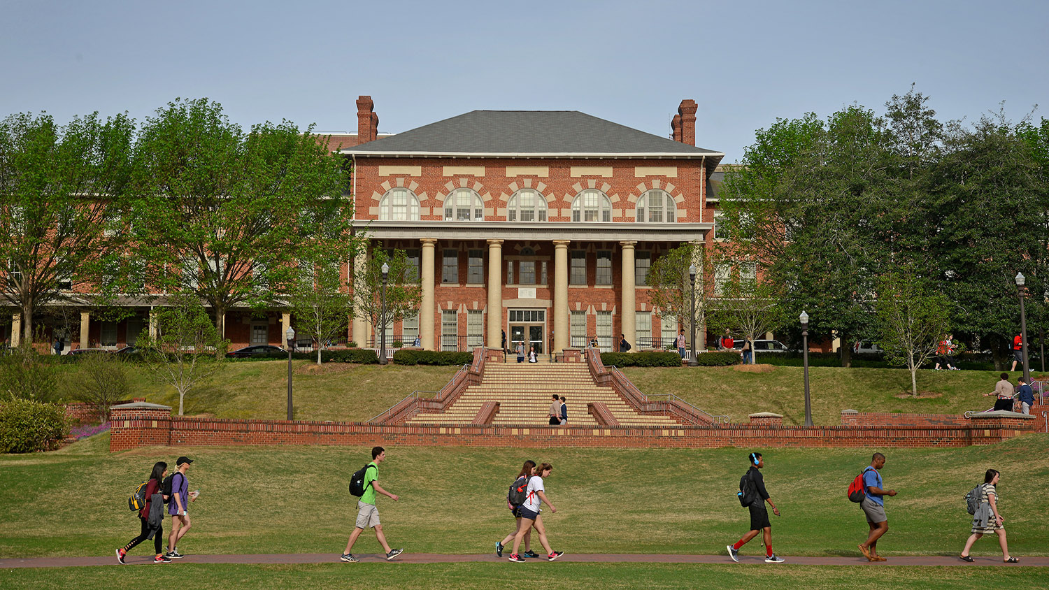 students walking across brick pathway