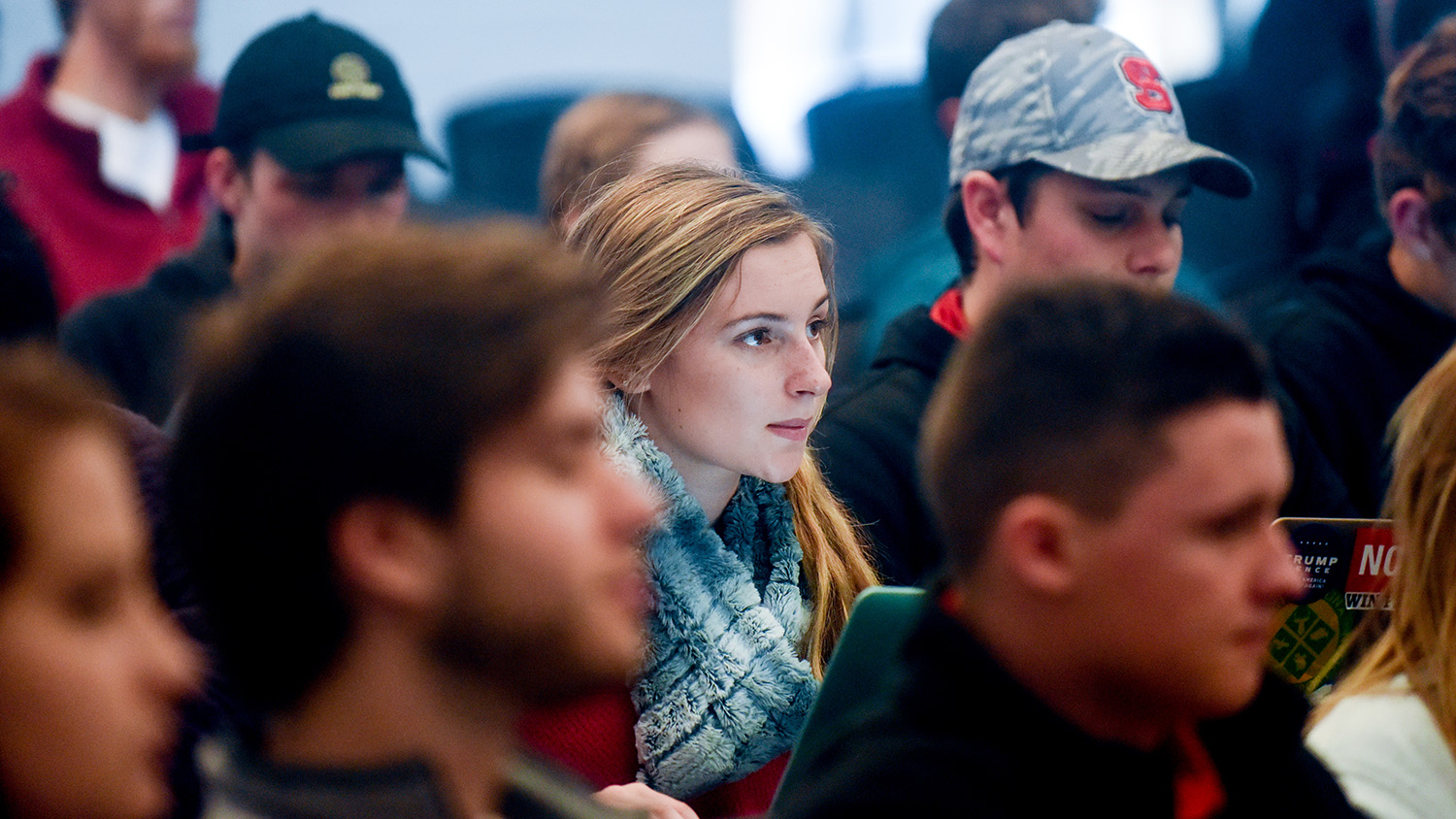woman wearing scarf sits in lecture hall