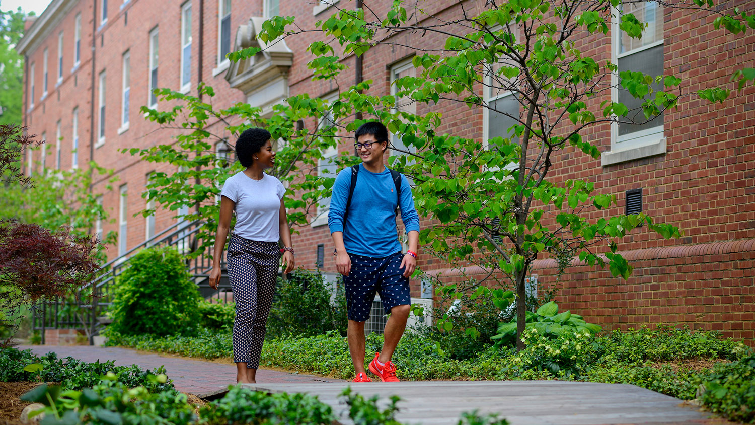 Undergraduate students gather by flowers near Tucker beach and in between residence halls on main campus.