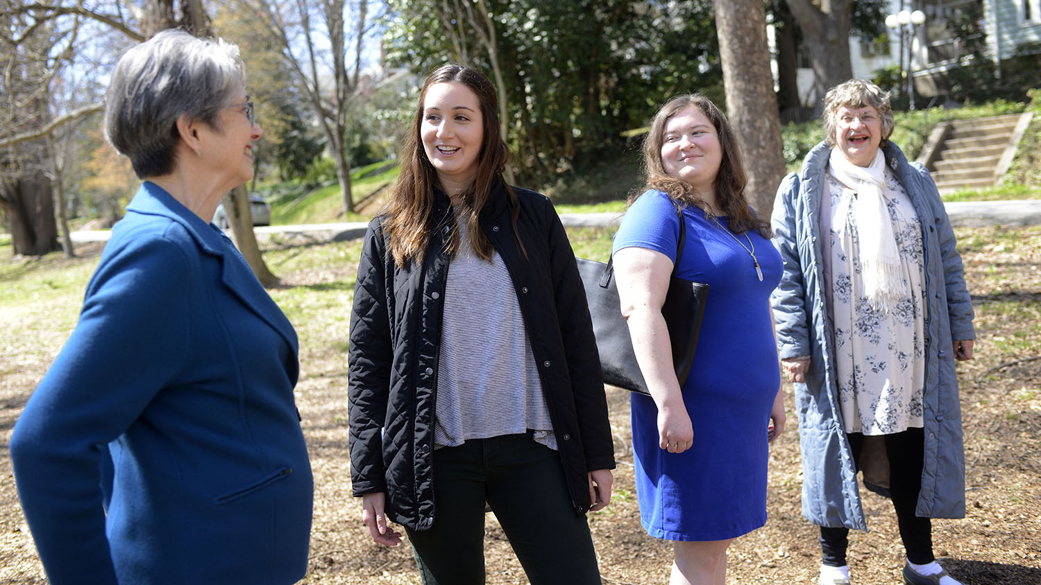 Social Work students stand with two residents of Raleigh.