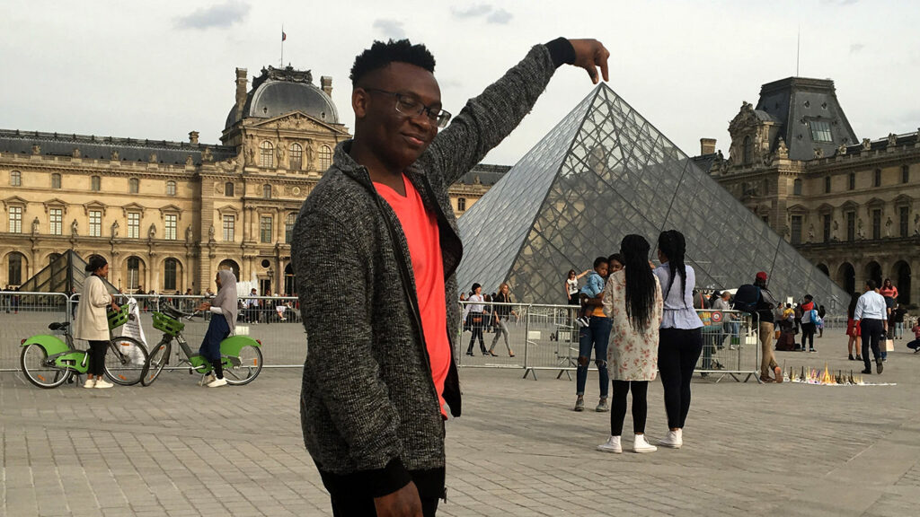 student standing in front of Louvre