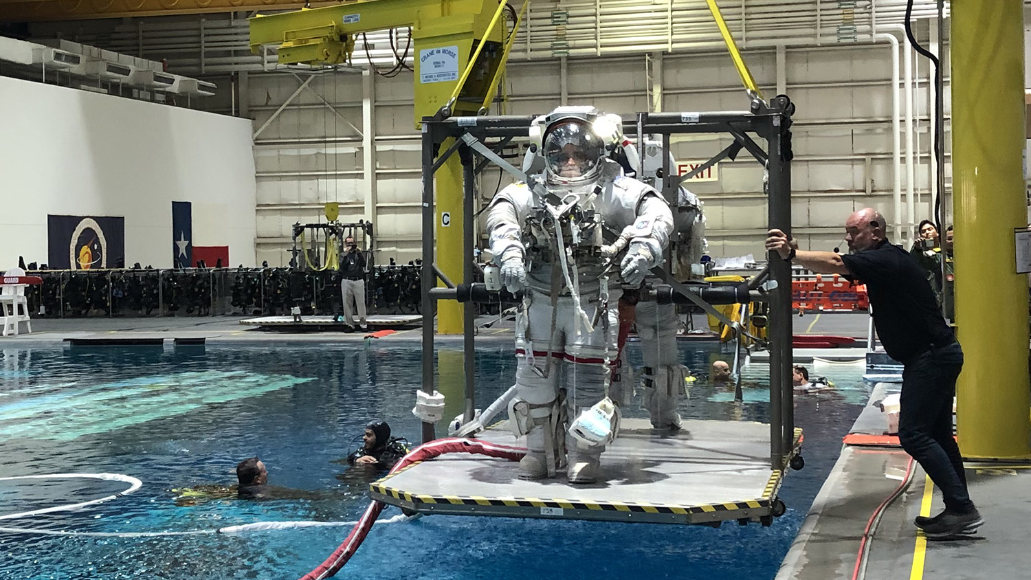 Two astronaut candidates are raised from a buoyancy tank after training