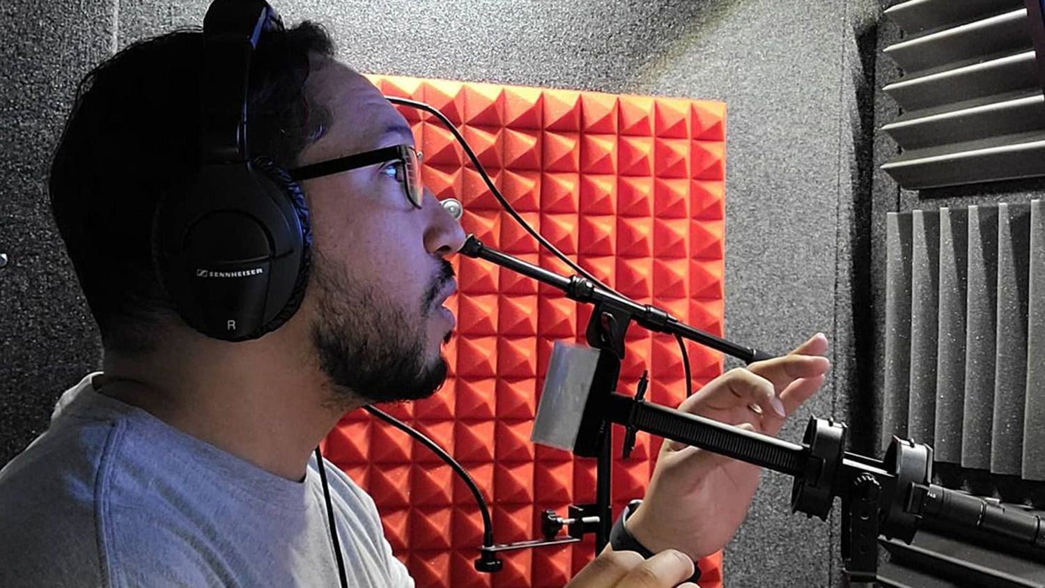 Donovan Corneetz wears a headset while speaking into microphone