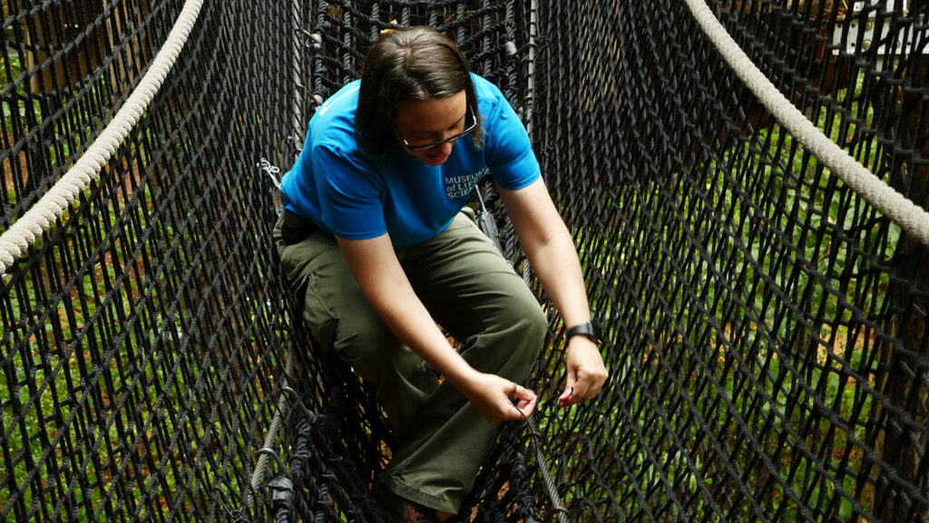 Jill Brown fixes rope bridge in museum exhibit