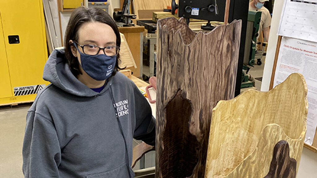 Jill Brown stands next to sleeping logs designed by her team