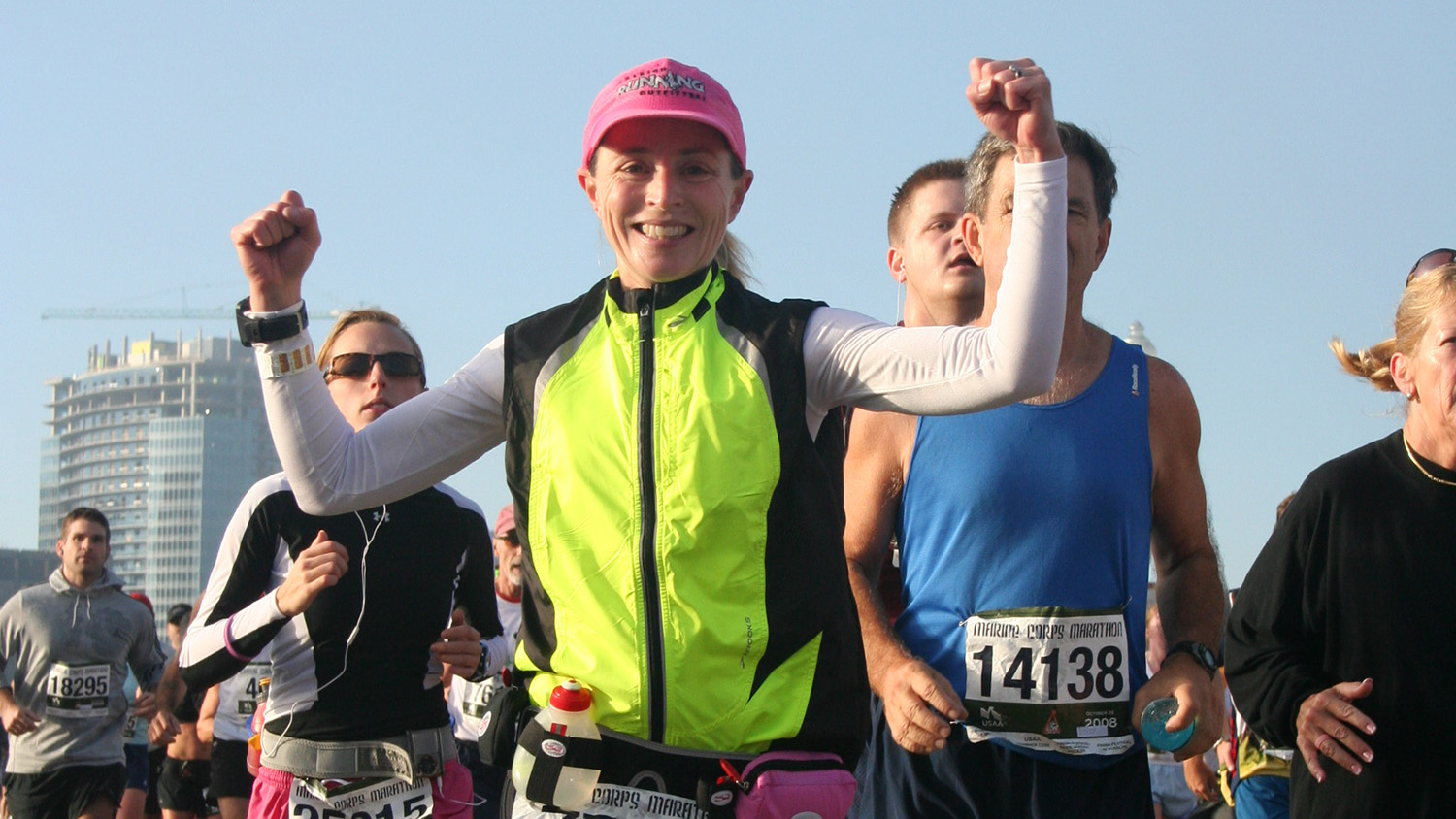 woman wearing yellow vest running in marathon