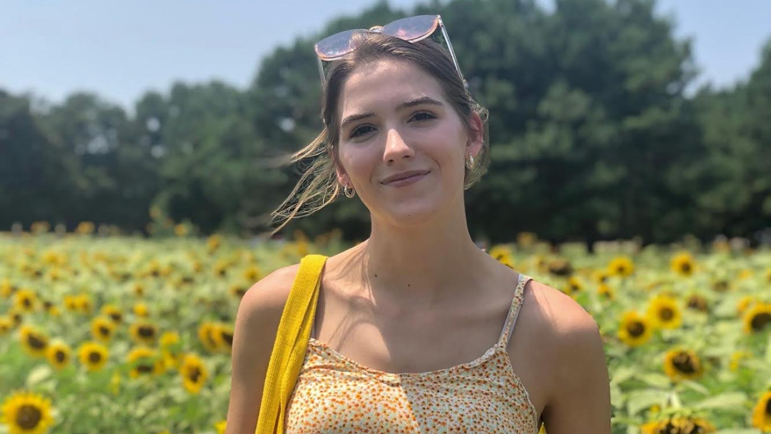 Sophie Korenek standing in front of sunflowers