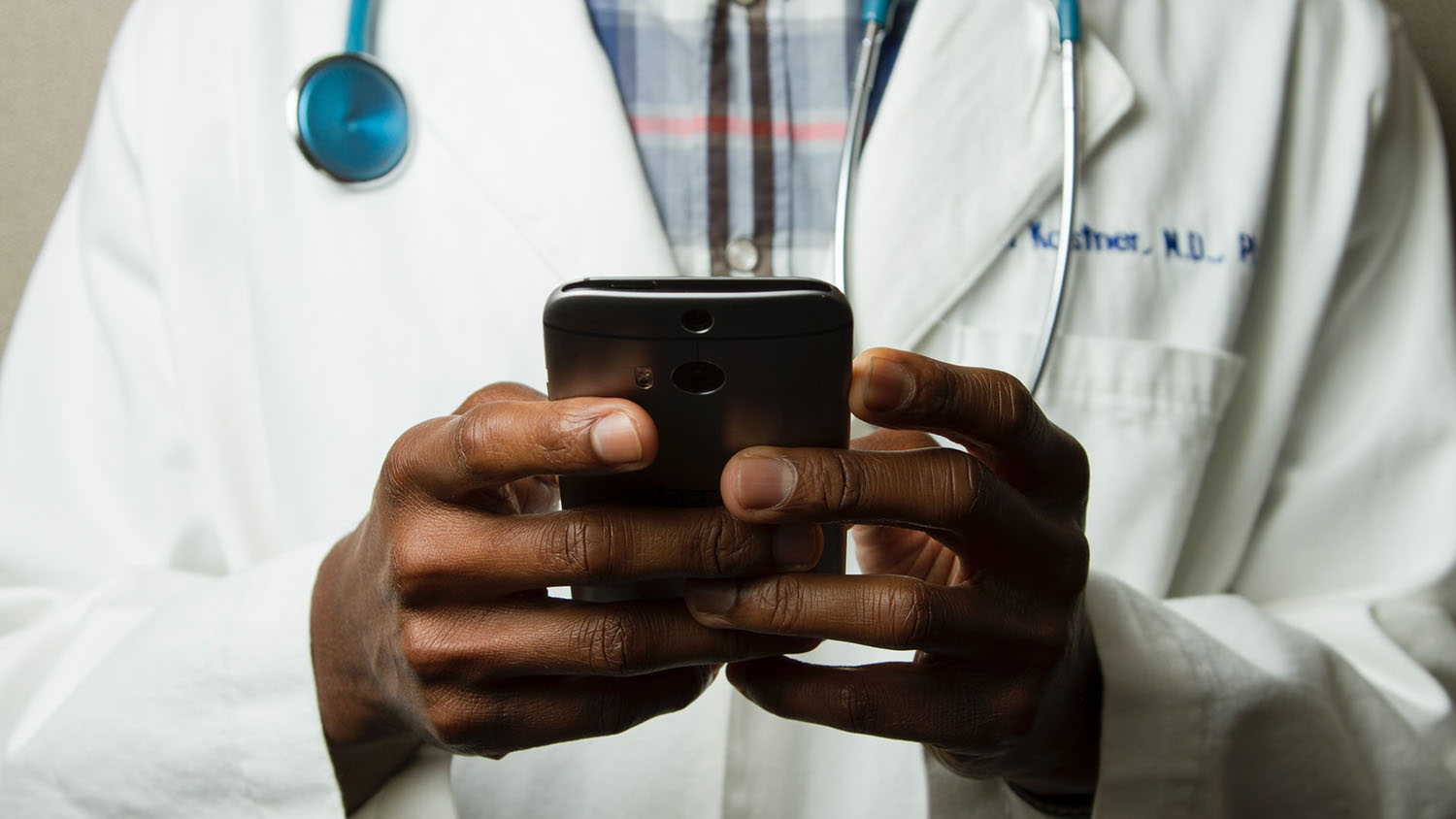 a doctor looks something up on a handheld device