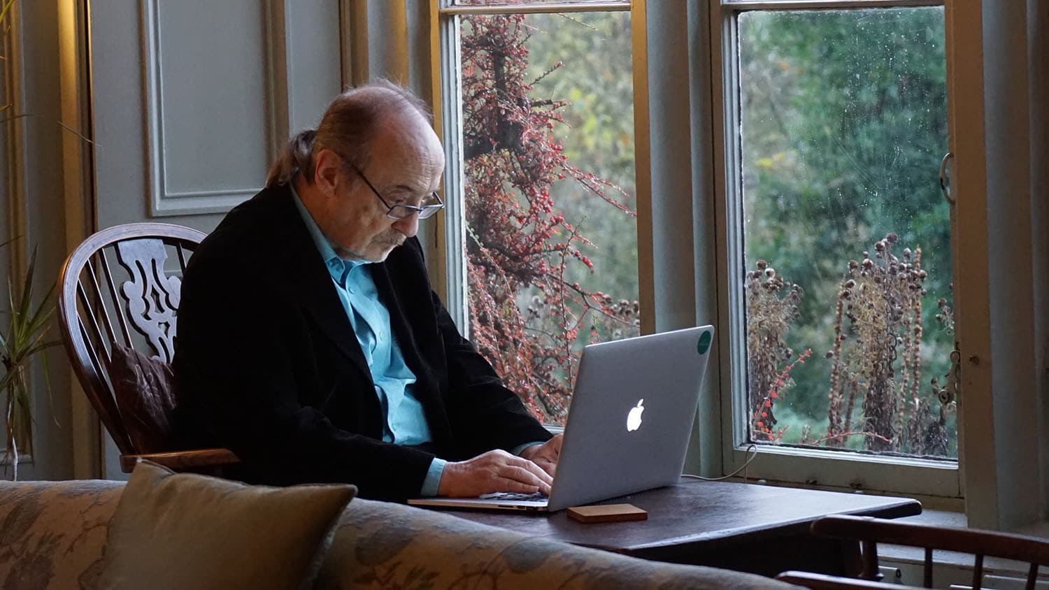 an older man looks at his computer screen
