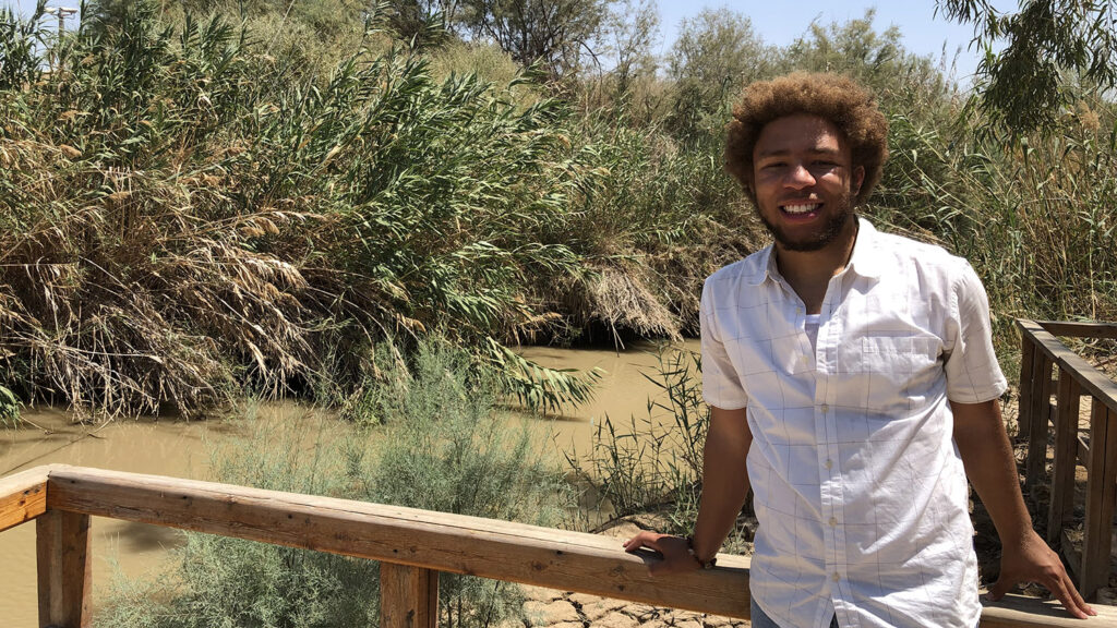 Anthony Ramsey stands next to the Jordan River