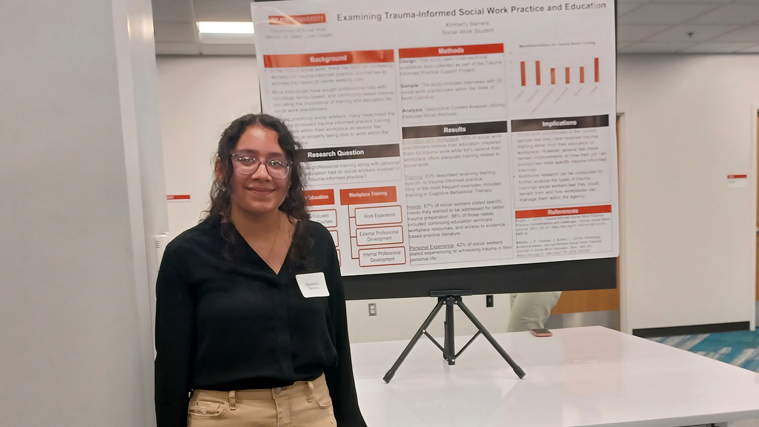 Kimberly Barrera-Gutierrez stands in front of a research poster