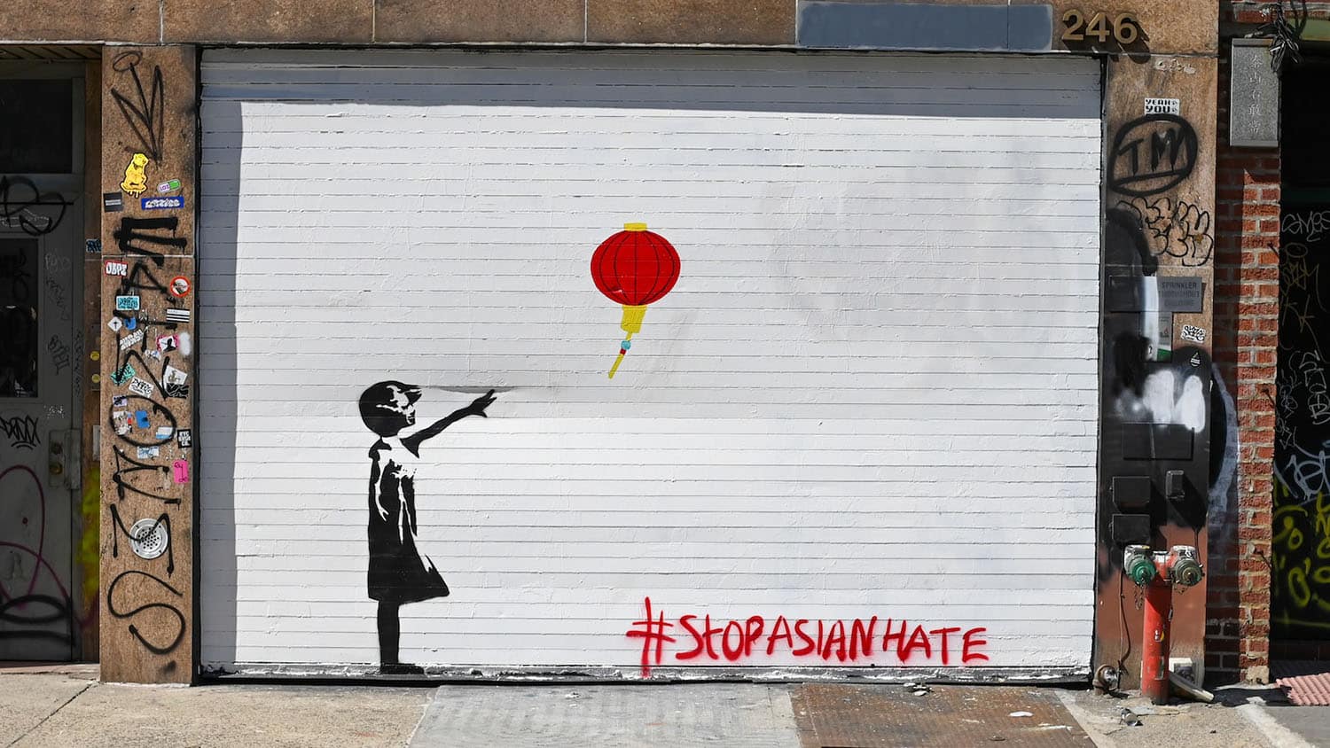 painting shows a child in silhouette as a red lantern drifts away from her hand. The hashtag #StopAsianHate is written near the bottom