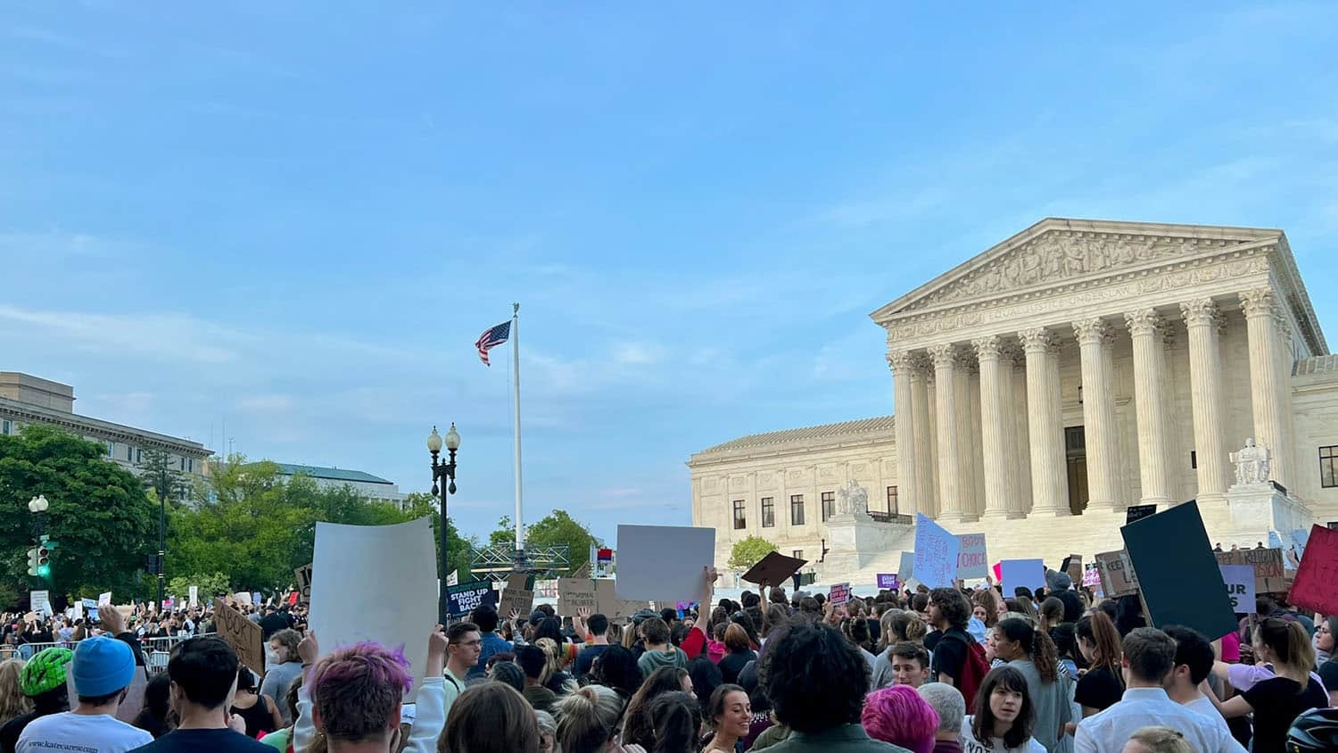 a group of protesters is gathered in front of the U.S. Supreme court