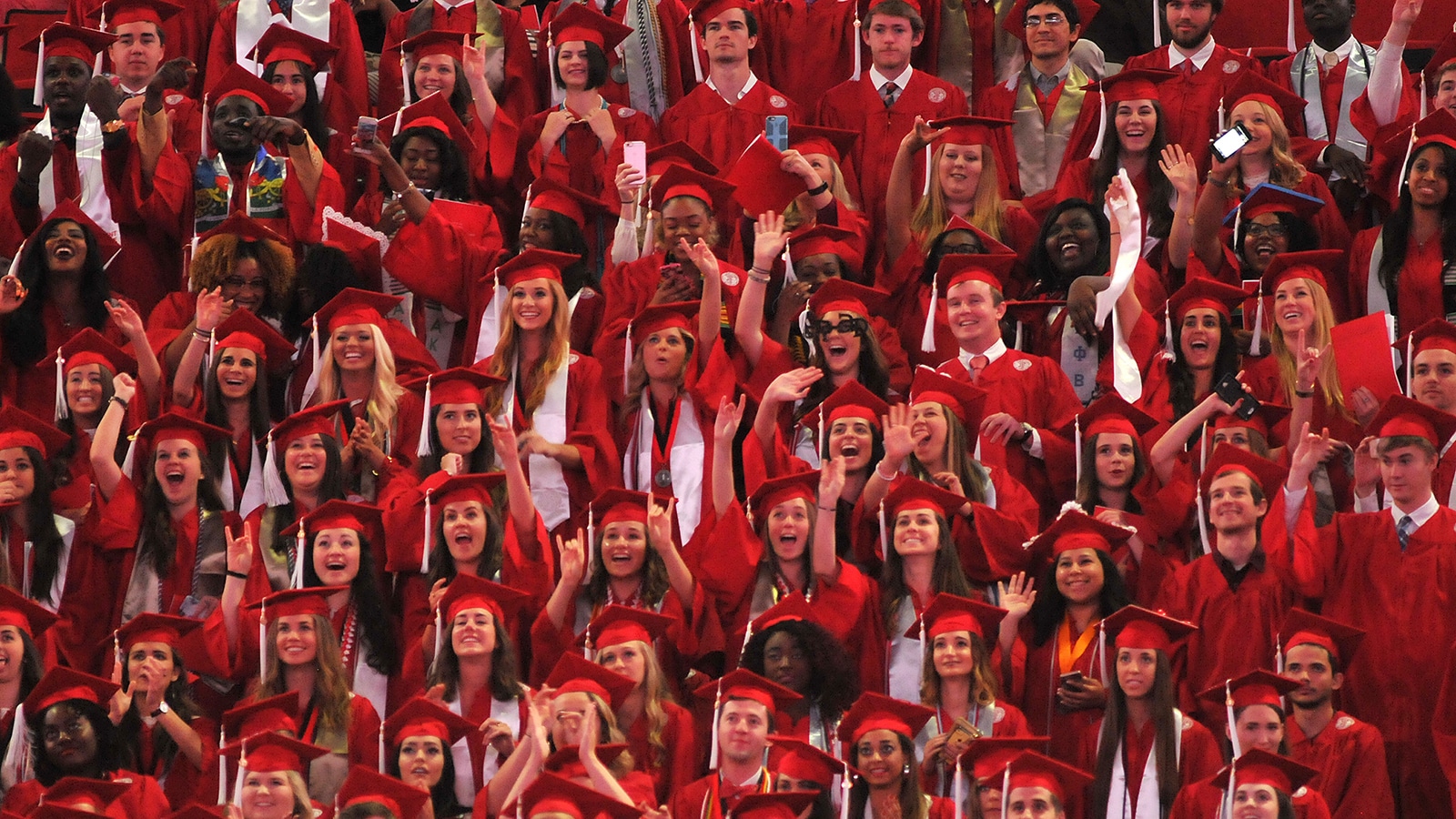 Graduates wearing caps and gowns celebrate