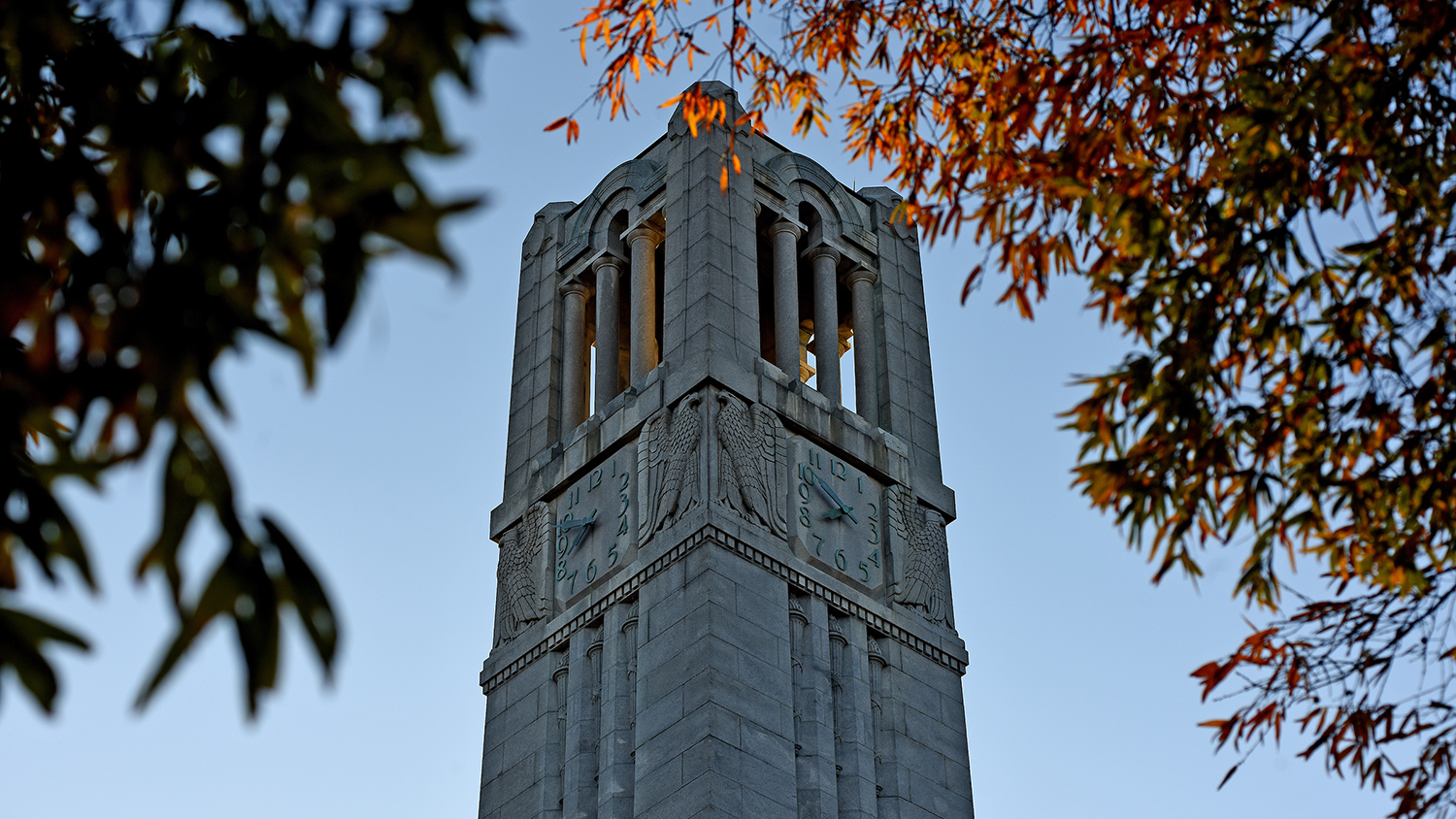 belltower peaks out of changing fall leaves