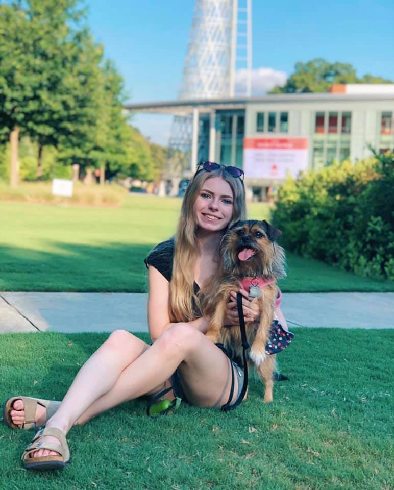 Addy Miller sitting in front of Talley Student Union with dog