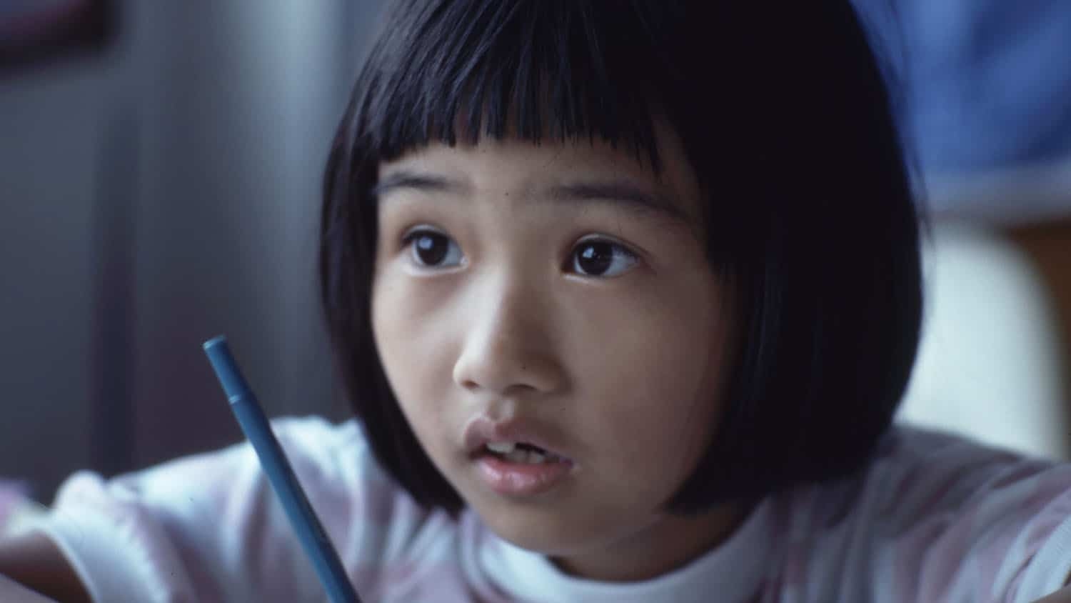 school-aged child at desk, looking ahead with mouth open