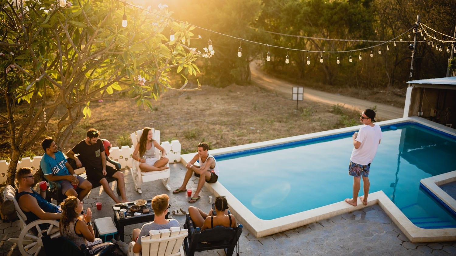 group of people at an outdoor party with one person standing apart from the others